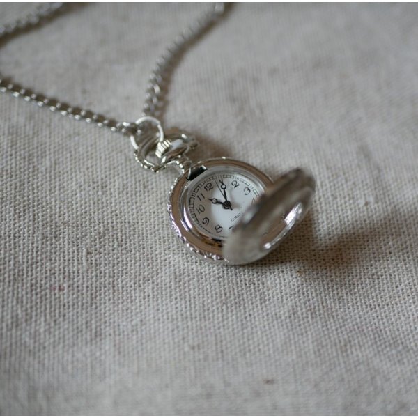 Pendente de bolso redondo prateado sobre corrente